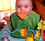 Baby mit Keks im Mund